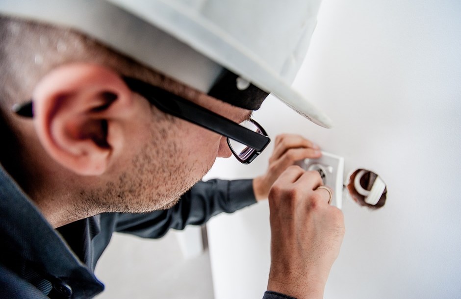 Electrician working with a socket or switch fitting
