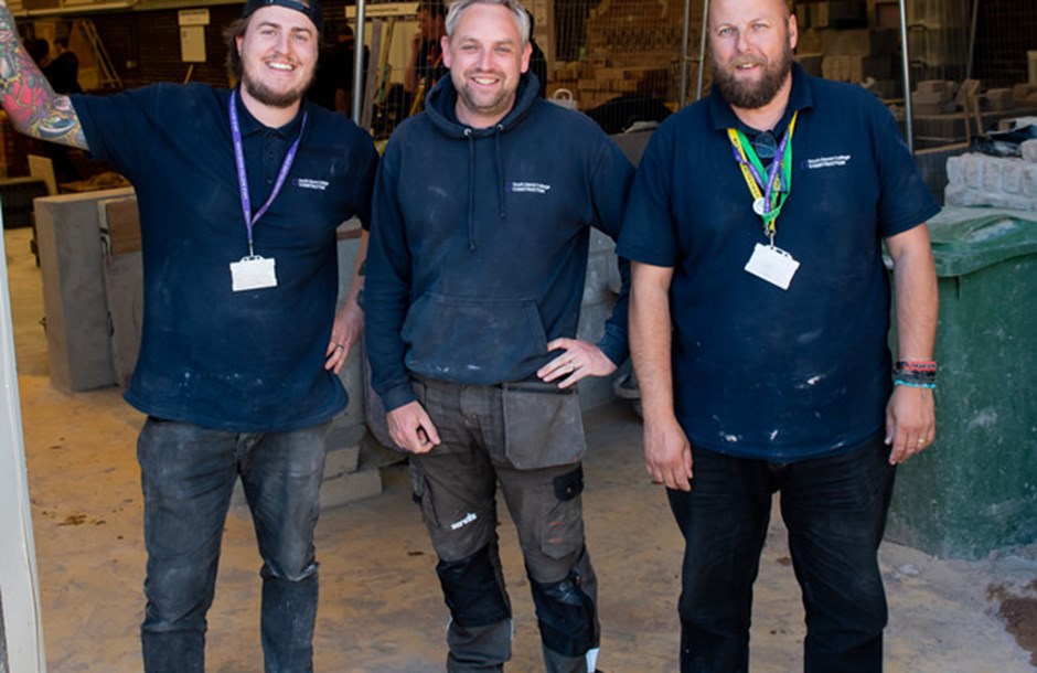 Three male construction workers smiling